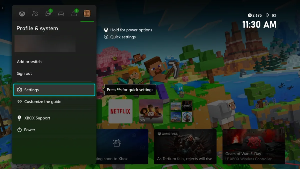 The Xbox guide open on the Profile and system tab. The menu lists Add or switch, Sign out, Settings, Customize the guide, XBOX Support and Power. Settings is highlighted. The account name and gamertag are blurred out.